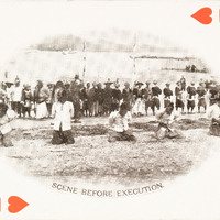 The 2 of hearts with a picture of 5 men on the beach kneeling with a large crowd behind them.